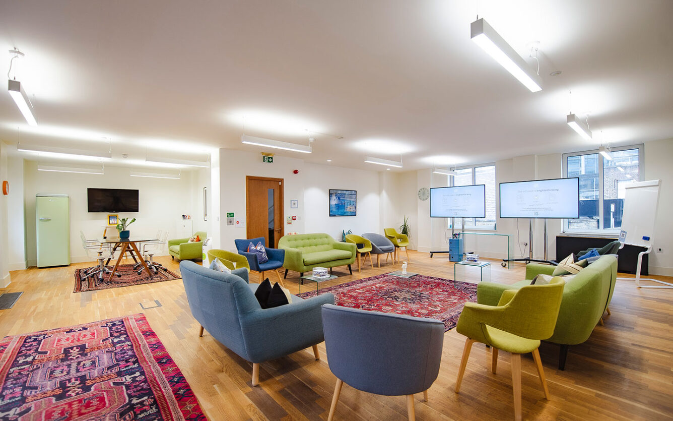 Large meeting room with colourful soft seating and breakout area for workshops, training and research