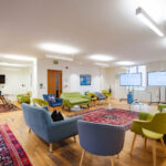 Large meeting room with colourful soft seating and breakout area for workshops, training and research